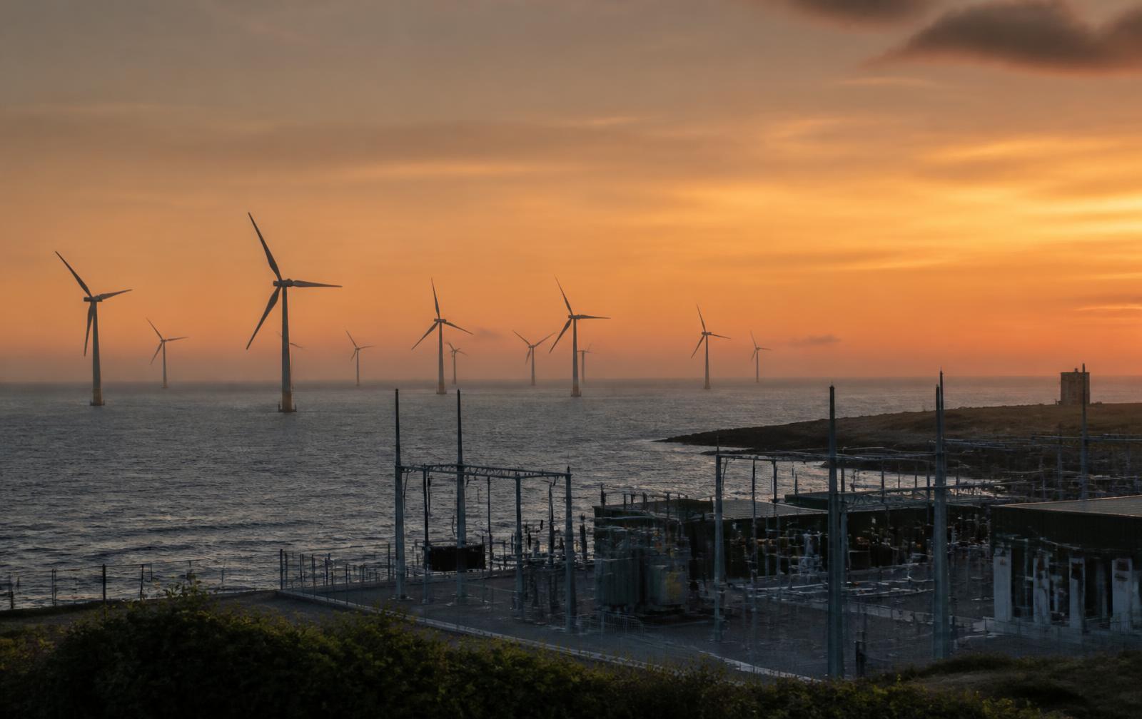 Wind, solar and electrical grid infrastructure at sunset